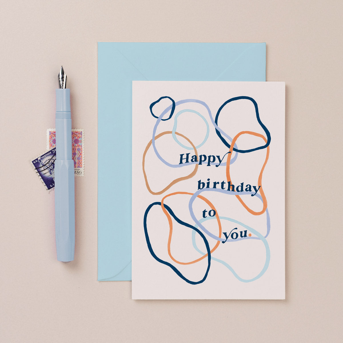 A simple birthday card with happy birthday lettering and abstract hoop pattern on a birthday card from the birthday card collection at Sister Paper Co.