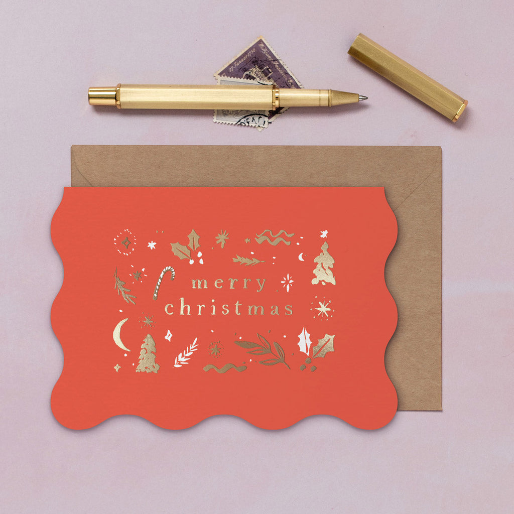 A red wavy edge Christmas card with sparkly gold foil details from the Sister Paper Co. collection of Christmas cards.