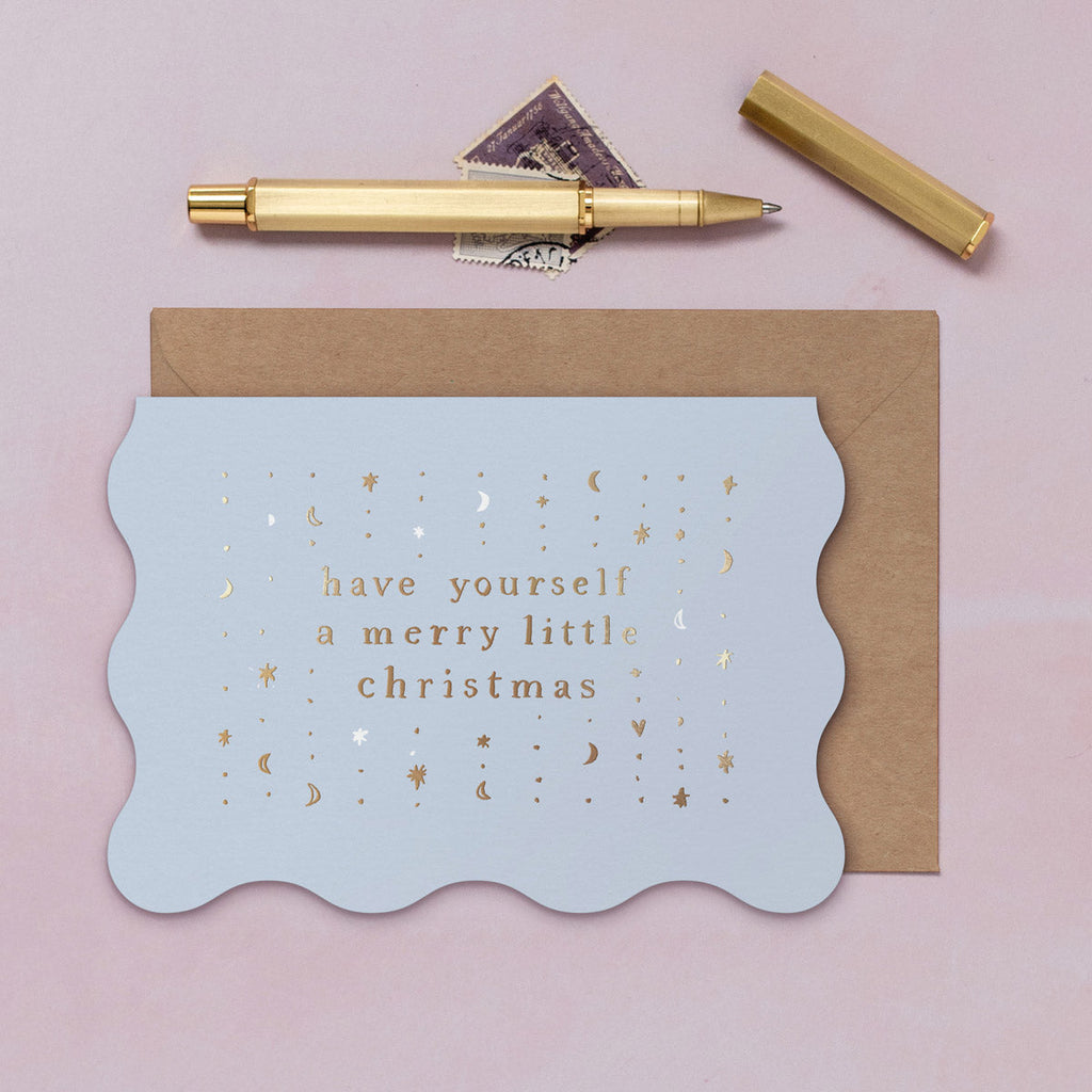 A lilac wavy edge Christmas card with sparkly gold foil details from the Sister Paper Co. collection of Christmas cards.