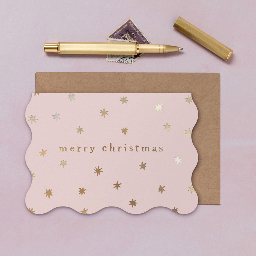 A wavy edge Christmas card with sparkly gold foil stars from the Sister Paper Co. collection of Christmas cards.