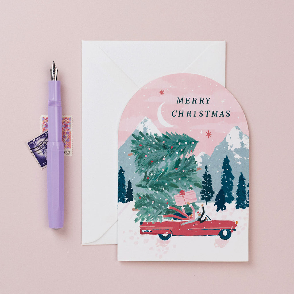 A Christmas card featuring a convertible car stacked with Christmas trees from the Nevada holiday card collection at Sister Paper Co.