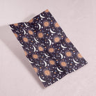 A sun and moons print adorns this sun gift wrap from the w wrapping paper sheets collection at Sister Paper Co.