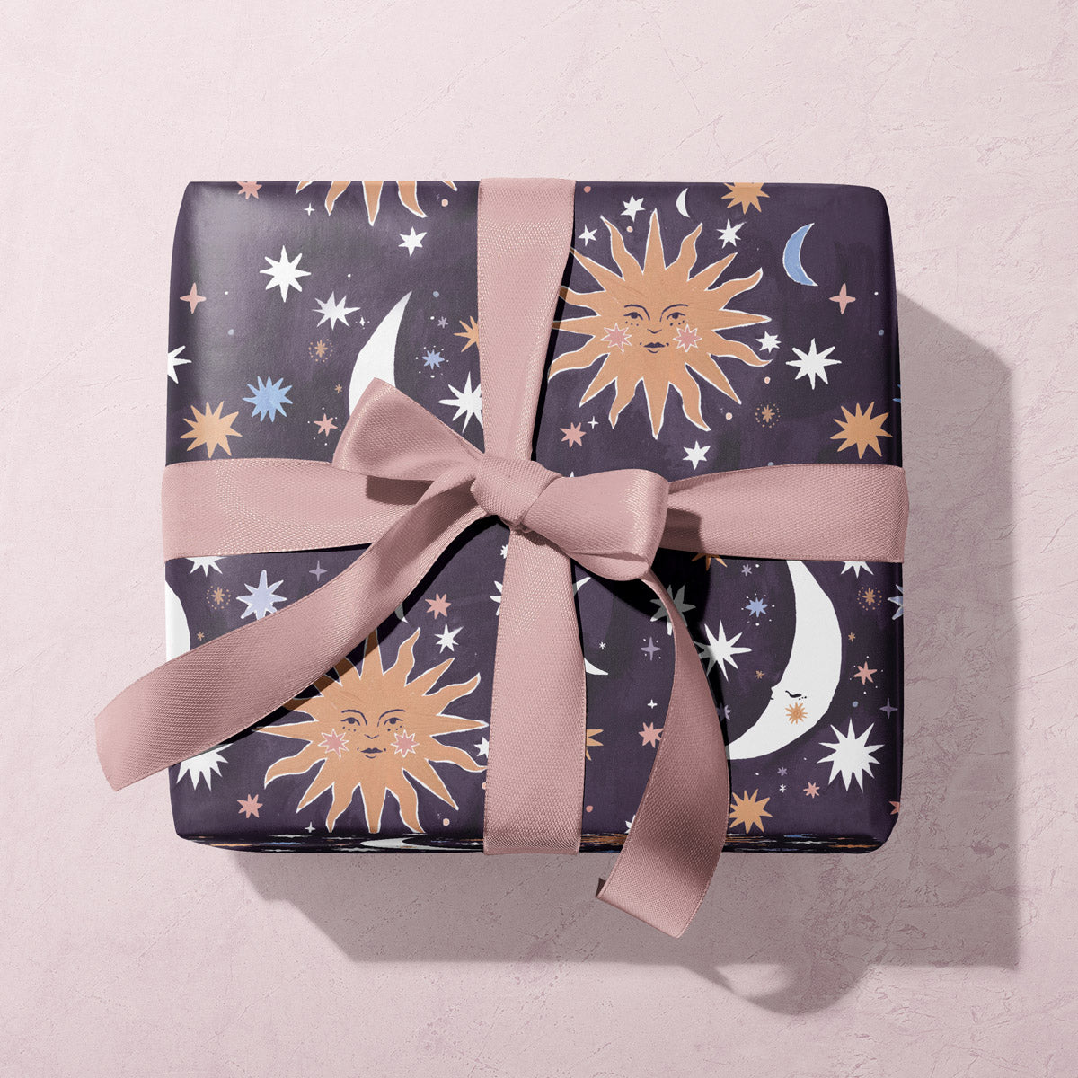 A sun and moons print adorns this sun gift wrap from the wholesale wrapping paper sheets collection at Sister Paper Co.