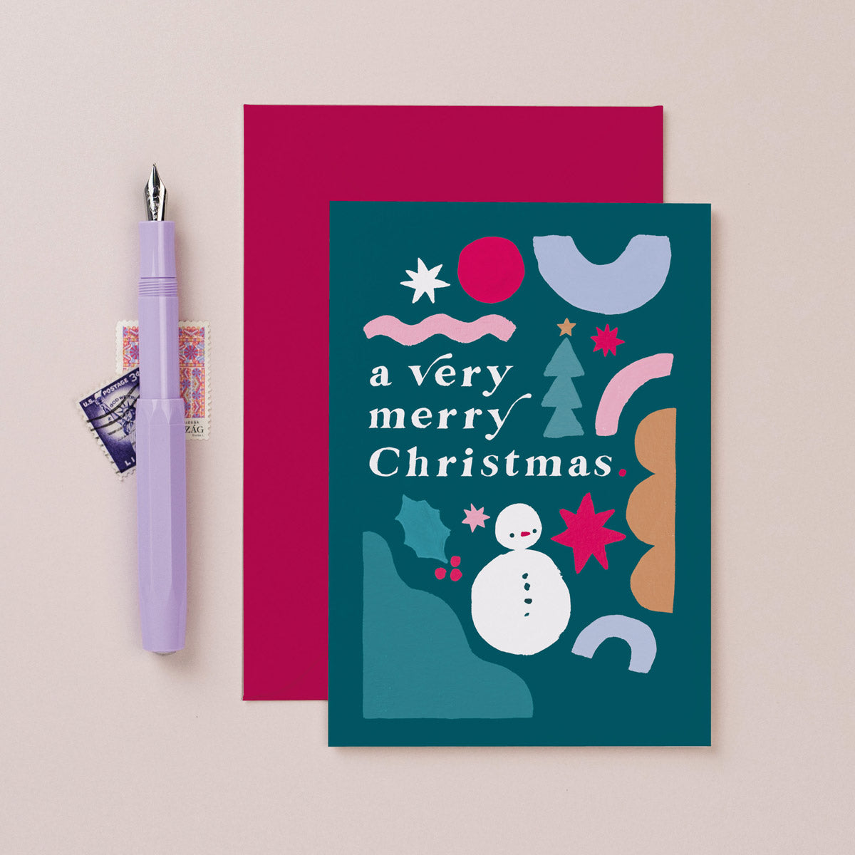 A rainbow with fun merry and bright lettering on a Christmas card from the colourful, rainbow Christmas card collection at Sister Paper Co.