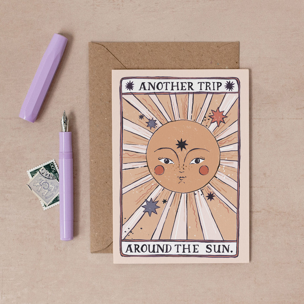 A handmade tarot style card with illustrated beautiful sun and another trip around the sun hand lettering on a birthday card from the female birthday card collection at Sister Paper Co.