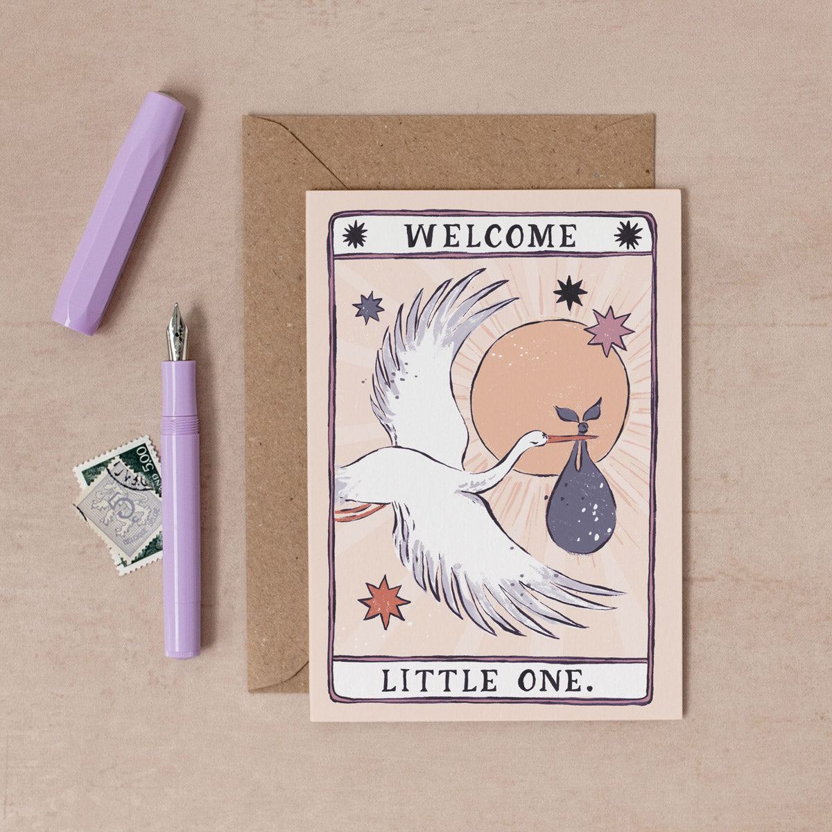 A gender neutral baby card with illustrated stork and welcome little one hand lettering on a new baby card from the unisex baby collection at Sister Paper Co.